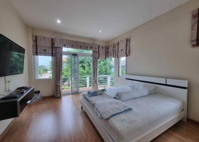 Spacious bedroom with balcony and modern furnishings