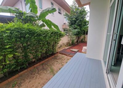 Backyard with wooden deck and lush greenery