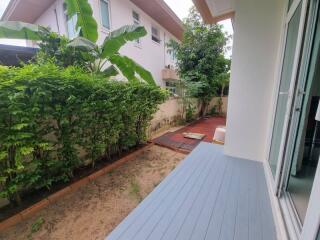 Backyard with wooden deck and lush greenery