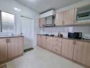 Modern kitchen with wooden cabinets, appliances, and tiled flooring