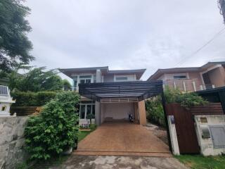 Modern two-story house with driveway and greenery