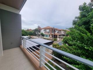View from balcony overlooking residential neighborhood with greenery
