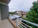 View from balcony overlooking residential neighborhood with greenery