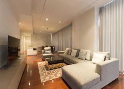 Modern living room with sofa, TV, and dining area