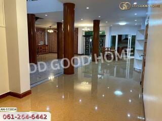 Spacious living room with polished floors and wooden columns