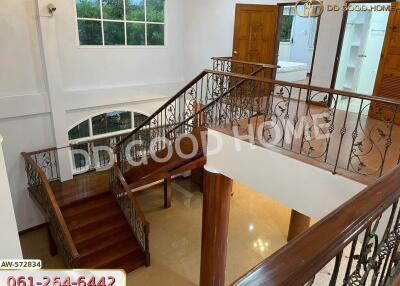 Spacious interior with wooden staircase and decorative iron railings