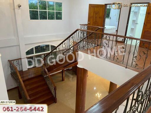 Spacious interior with wooden staircase and decorative iron railings