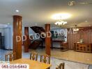 Spacious living and dining area with wooden pillars and a stairway