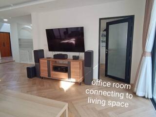 Living room with an office area and large TV setup