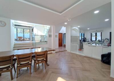 Spacious open-plan kitchen and dining area with wooden flooring and ample natural light
