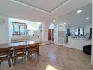 Spacious open-plan kitchen and dining area with wooden flooring and ample natural light