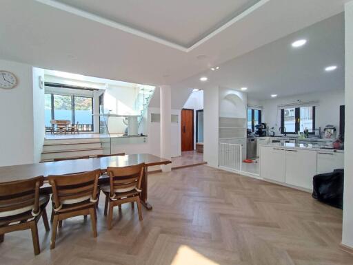 Spacious open-plan kitchen and dining area with wooden flooring and ample natural light