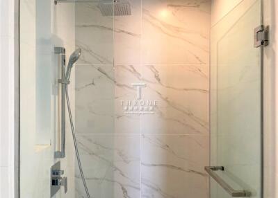 Modern bathroom with glass shower door and marble tile