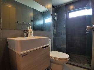 Modern bathroom with sink, toilet, and shower