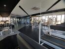 Modern gym with various exercise equipment and large windows