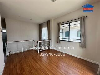 Living area with wooden flooring and windows