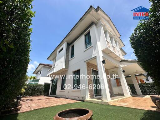 Two-story house with a manicured lawn and patio