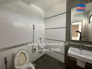 Modern bathroom with toilet, sink, and shower