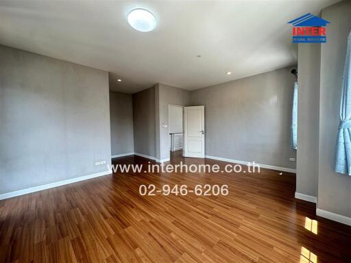 Spacious living area with wooden flooring and natural light