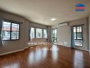 Spacious living room with wooden flooring and large windows