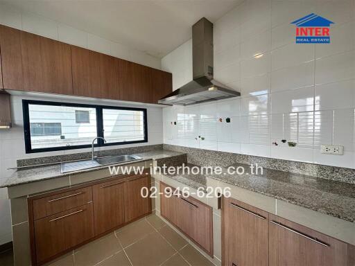 Modern kitchen with wooden cabinets, granite countertops, and stainless steel appliances.