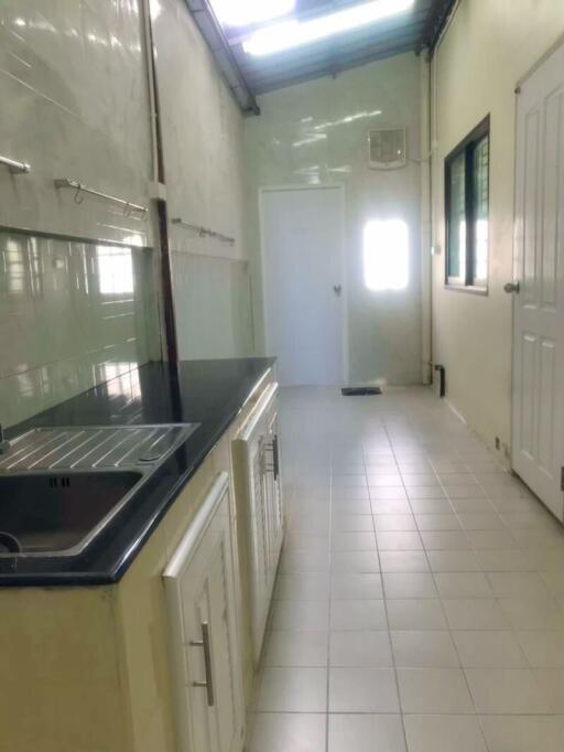 Narrow kitchen with tiled floor and countertop sink