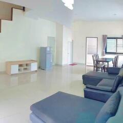 Spacious furnished living room with dining area and staircase