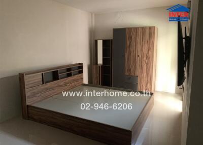 Spacious bedroom with wooden bed frame and wardrobe