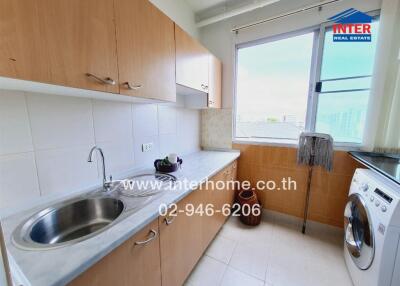 A kitchen with wooden cabinets, a sink, washing machine, and a window.