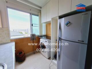 Kitchen with large window, washing machine, and refrigerator