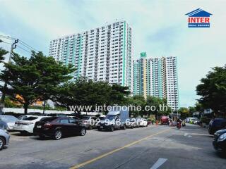 Exterior view of apartment buildings with a parking area and street