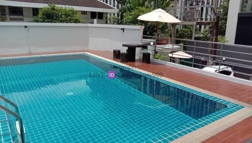 Outdoor pool area with seating and shade