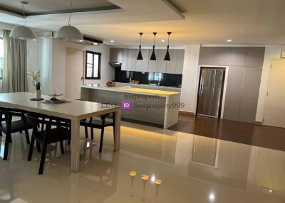 Modern kitchen and dining area with contemporary lighting and furniture