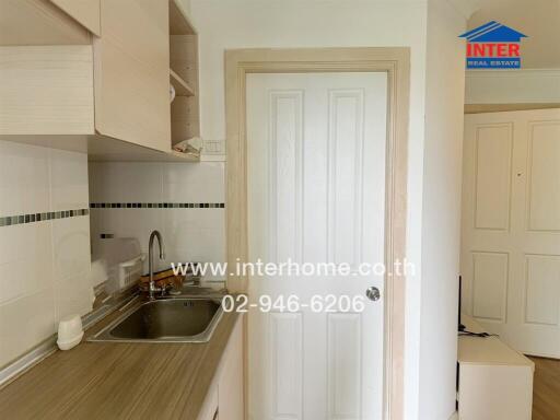 Small kitchen area with sink and cupboards