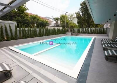Swimming pool with lounge chairs in a backyard