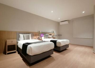 Spacious bedroom with two single beds and modern furnishings