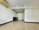 Main living area with wooden flooring, air conditioning, and a small kitchenette