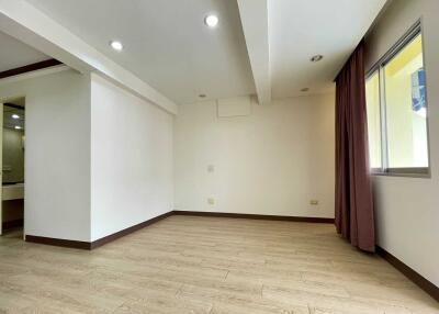 Unfurnished bedroom with wooden floors and large window