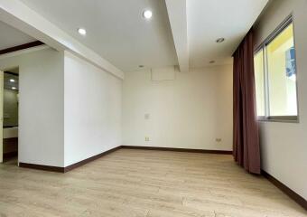 Unfurnished bedroom with wooden floors and large window