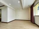 Unfurnished bedroom with wooden floors and large window