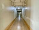 Long hallway with tiled flooring and overhead lighting