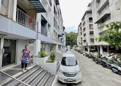 Exterior view of residential buildings with walkways and parked vehicles