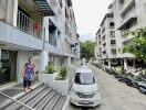 Exterior view of residential buildings with walkways and parked vehicles