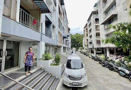 Exterior view of residential buildings with walkways and parked vehicles