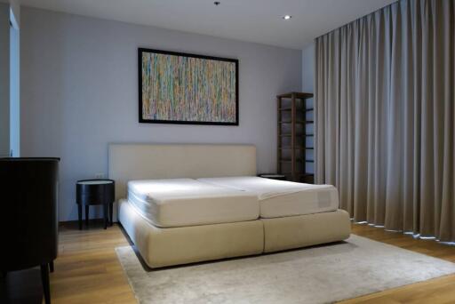 Modern bedroom with large bed and abstract painting