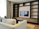 Modern living room with wall-mounted TV and built-in shelving