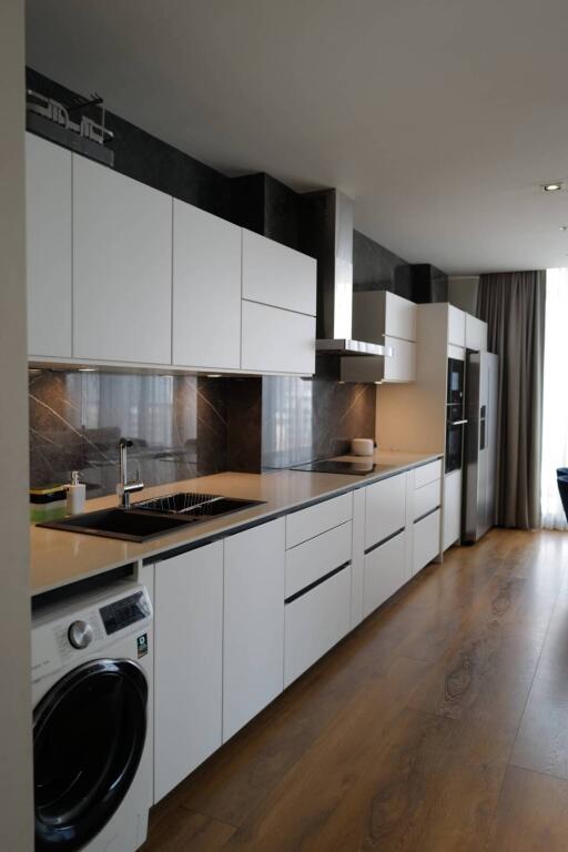 modern kitchen with white cabinets, black countertops, and built-in appliances