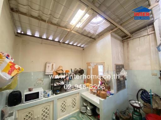 Small kitchen area with ceiling light and various kitchen items