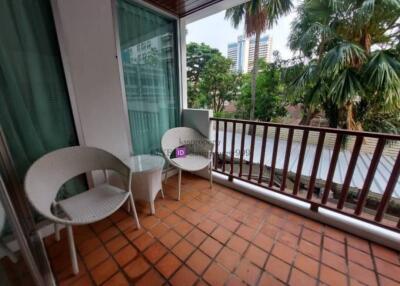 balcony with seating and a view of trees and buildings