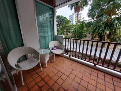 balcony with seating and a view of trees and buildings